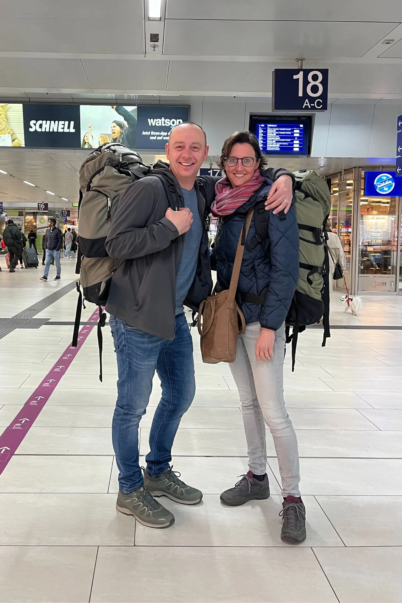  Twee backpackers, waar van een onze vrolijke collega, reisspecialist Susan wolfs, vrolijk poserend op het station, klaar om hun stedentrip naar München te beginnen. 