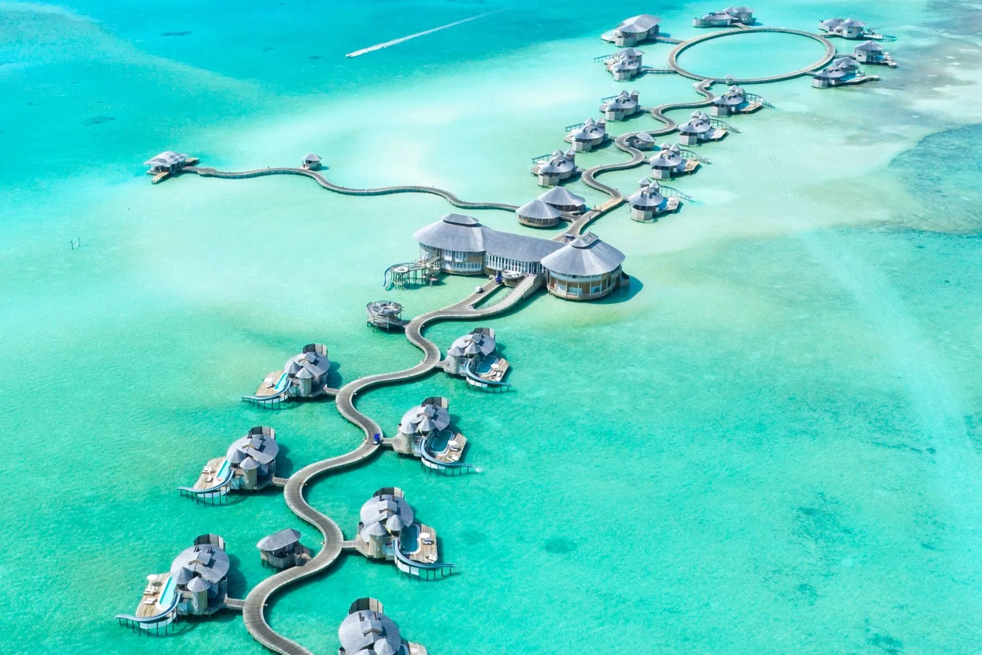 Een overzicht van het rustige Noonu Atol op de Malediven, met luxe villa’s en de uitgestrekte Indische Oceaan op de achtergrond.