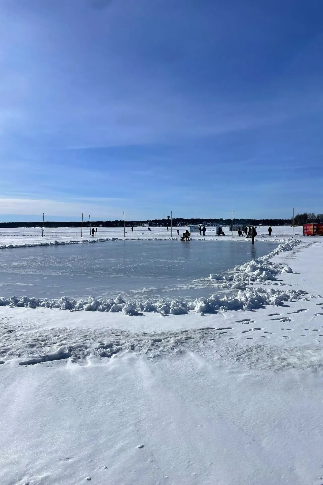 Een adembenemend winterlandschap in Zweden, met uitgestrekte vlaktes bedekt met sneeuw en ijs, onder een helderblauwe lucht.