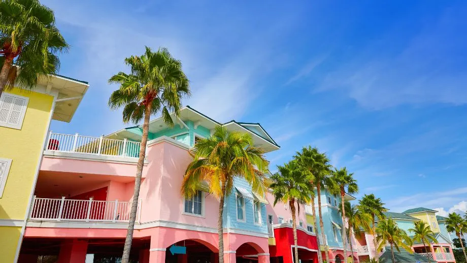 Pastelkleurige huizen in Fort Myers, omgeven door palmbomen tegen een heldere blauwe lucht.