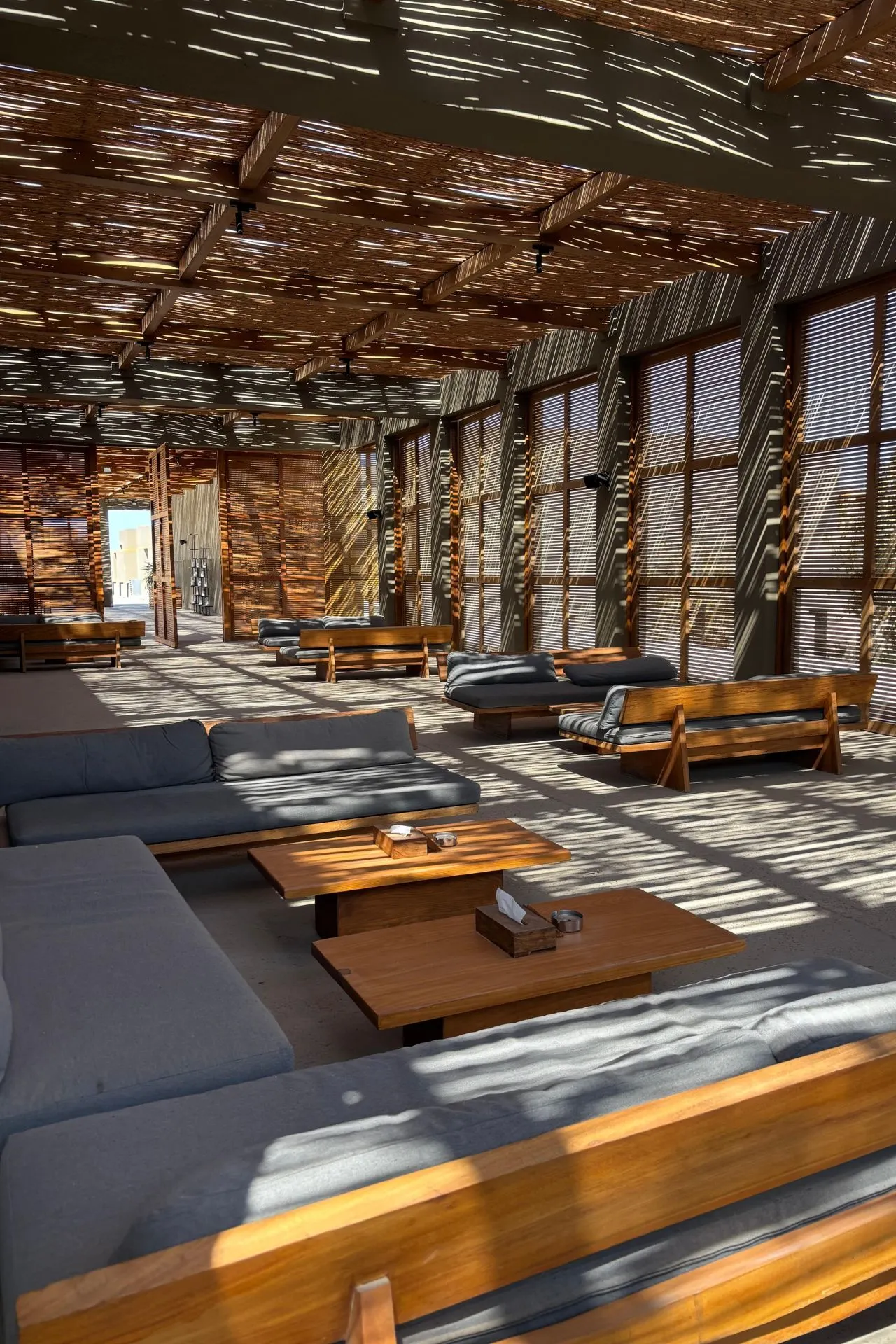 Bohemian lounge ruimte van Casa Cook El Gouna met houten overkapping en relaxte zitplaatsen
