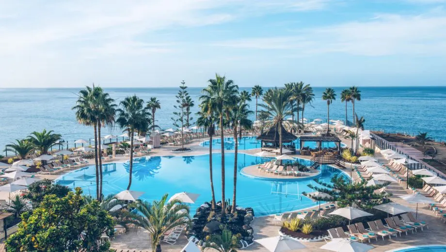 luxe zwembad bij Iberostar Selection Anthelia op Tenerife met palmbomen en uitzicht op zee
