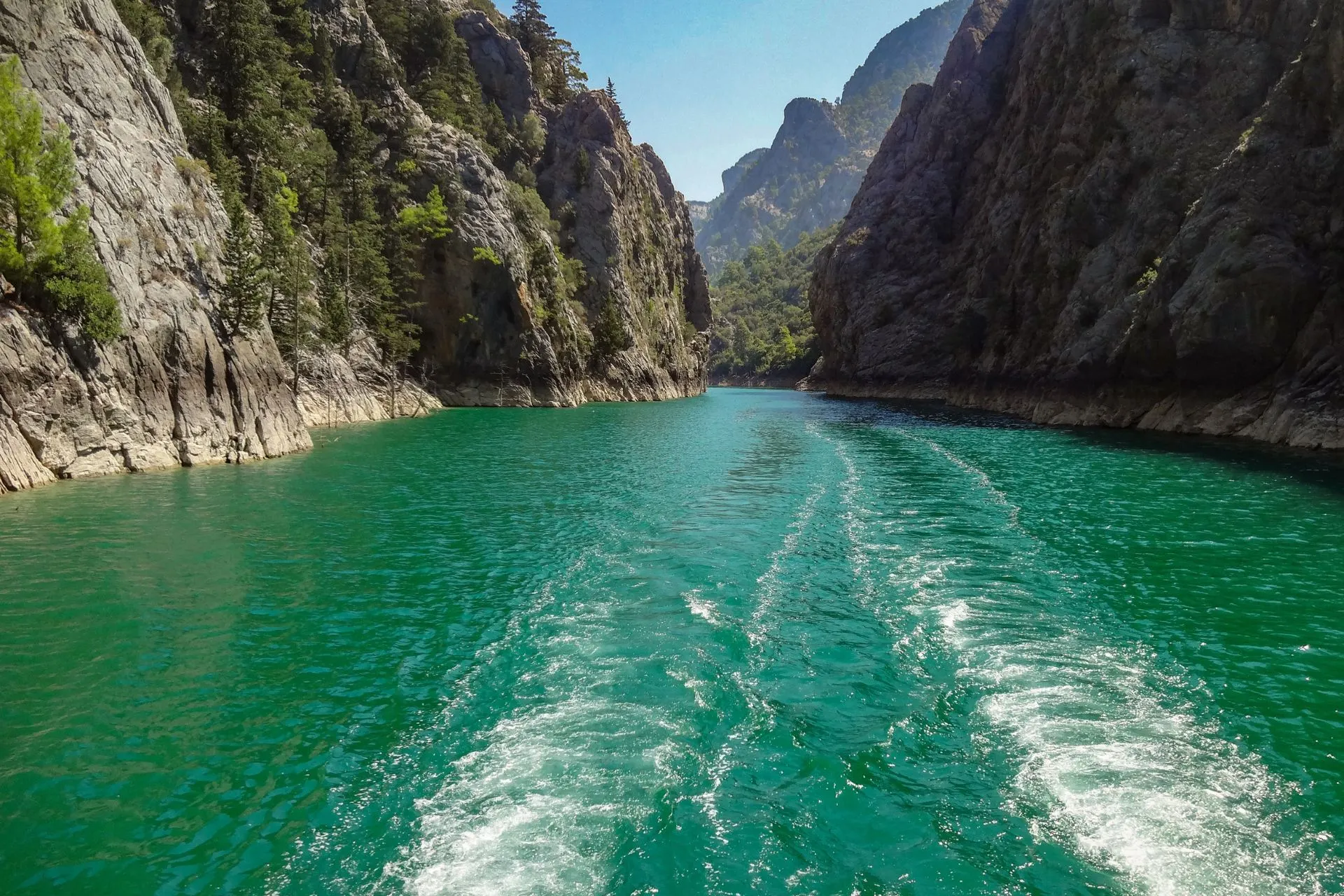Boottocht door de Green Canyon in Turkije, vlak bij Side en Manavgat. Het heldergroene water slingert tussen steile rotswanden en beboste berghellingen, terwijl de boot een spoor achterlaat op het rustige stuwmeer. Een populaire excursie vanuit Side voor liefhebbers van natuur, rust en indrukwekkende landschappen.
