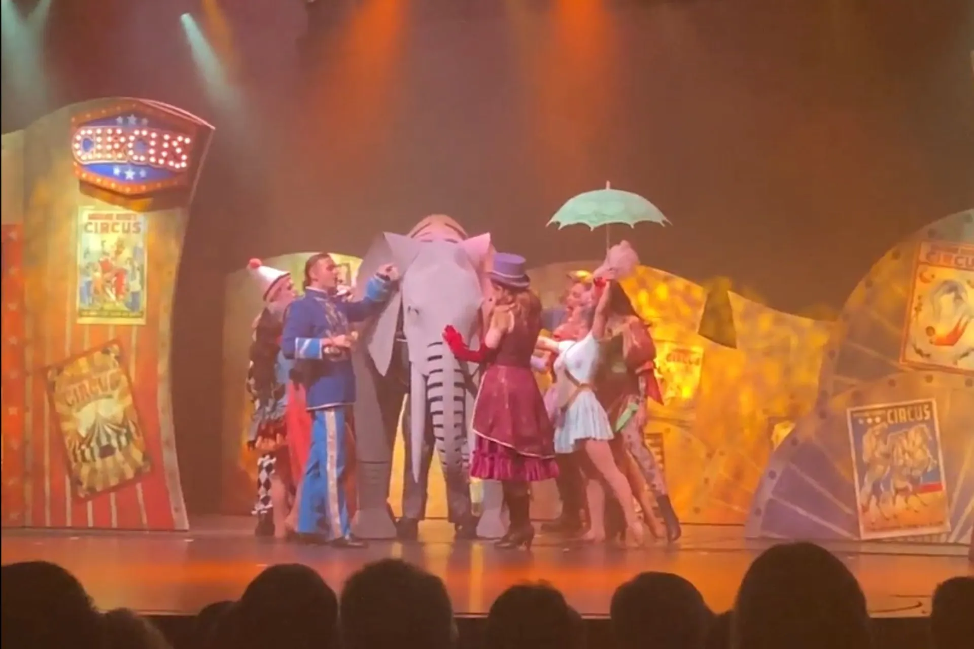 Artistieke voorstelling in circusthema op Marella Cruises, met artiesten die samen een scène met een olifant uitvoeren.
