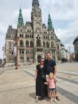 Leuke foto van 2 ouders met een dochtertje voor een kerk 