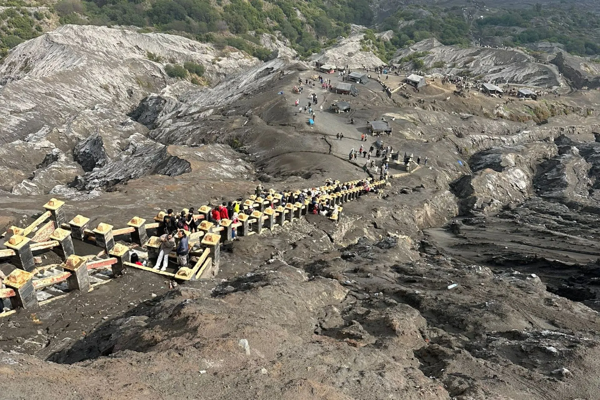 Trappen en wandelpad naar de krater van de actieve Bromo-vulkaan, omringd door vulkanisch landschap.