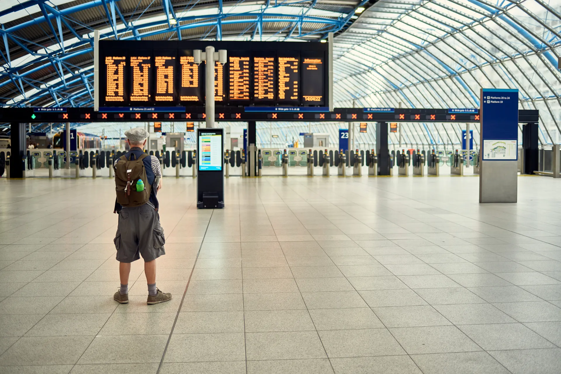 Oude man met petje wacht in de vertrekhal van Brussel Airport voor vertrek vanaf luchthaven Brussel of luchthaven Zaventem, ideaal om te vliegen vanaf Brussel of Zaventem.