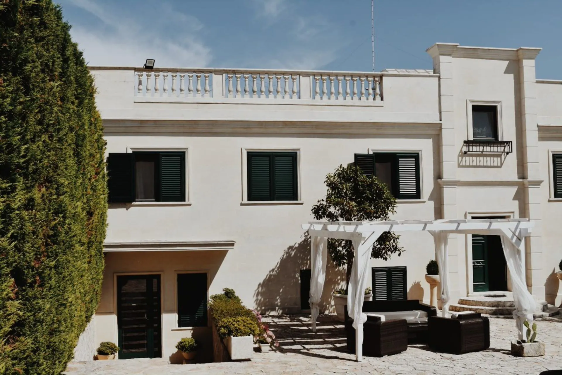 Elegante Italiaanse villa in Puglia met een zonnig terras en witte pergola.