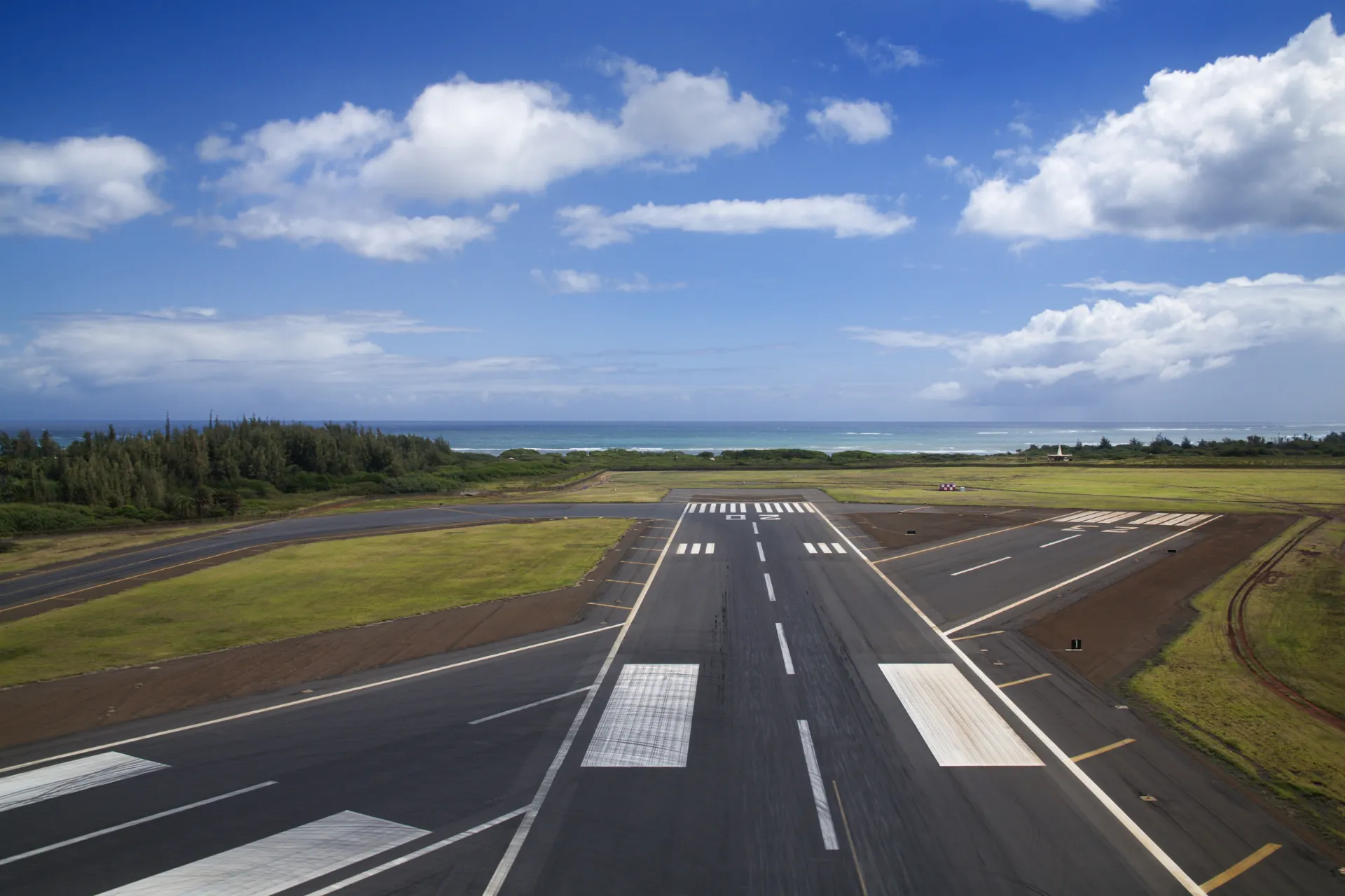 De landingsbaan van Groningen Airport onder een blauwe lucht, waar dagelijks vluchten vanaf Groningen Airport vertrekken voor een zorgeloos vliegen vanaf Groningen.
