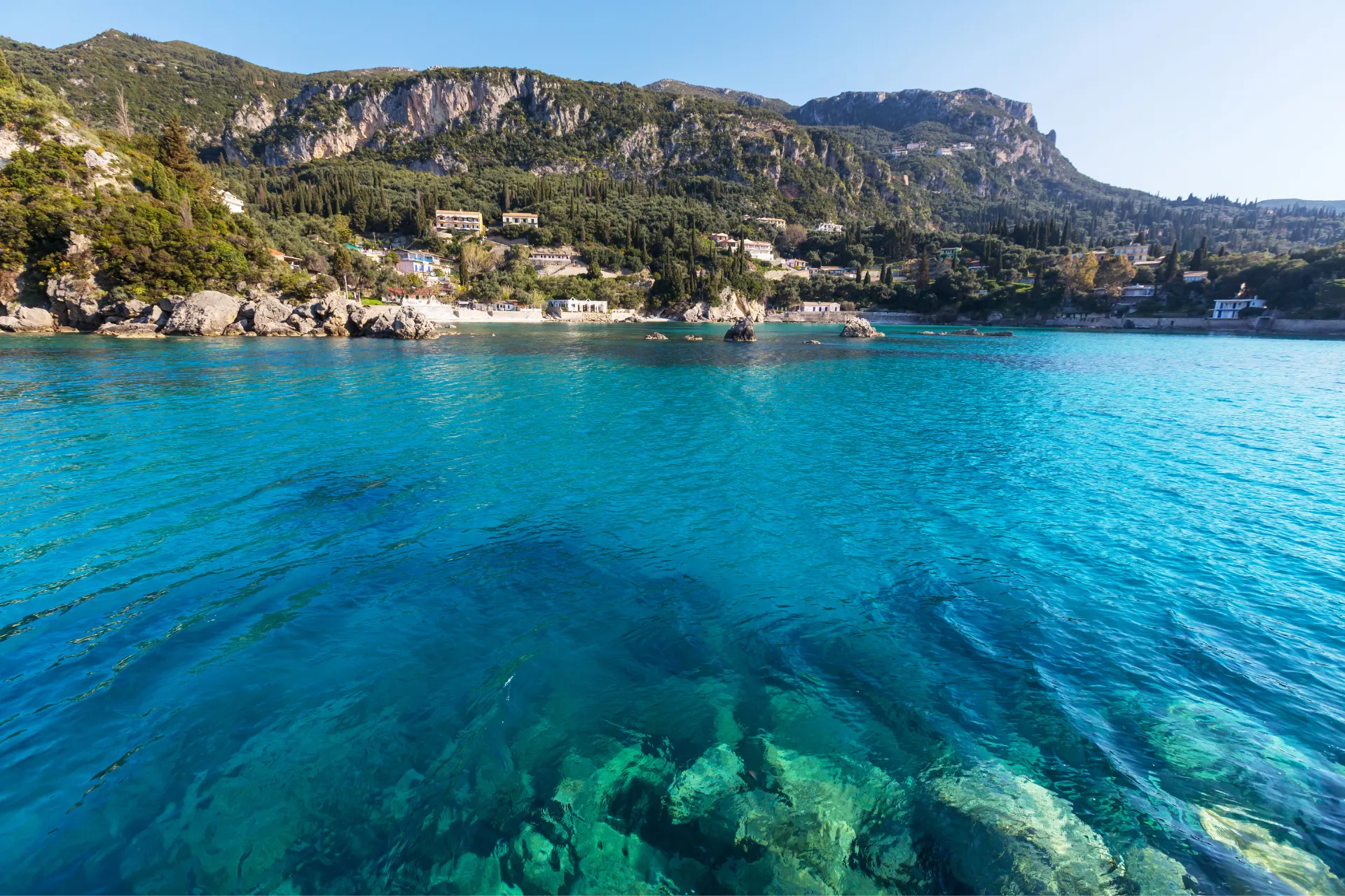 "Adembenemende kustlijn met helder turquoise water en groene heuvels op de achtergrond, ideaal voor een zonovergoten mediterrane vakantie. Kristalheldere zee, rotsachtige kust en pittoreske dorpjes maken deze bestemming perfect voor ontspanning, zwemmen en fotografie. Ongerepte natuur, panoramisch uitzicht en authentieke sfeer creëren een paradijs voor reizigers die houden van rust, avontuur en unieke landschappen."