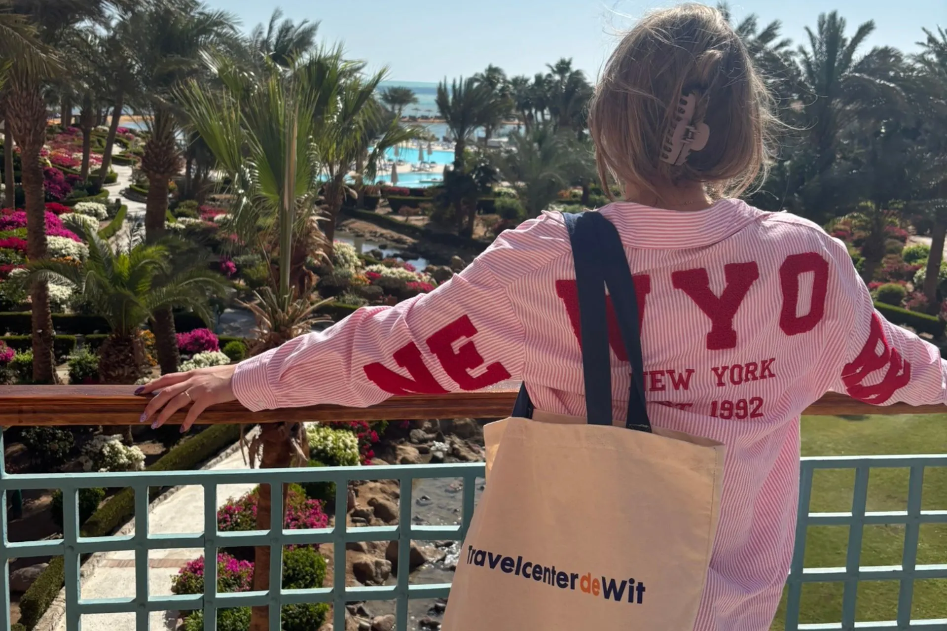 Uitzicht over een groen resort in El Gouna met palmbomen, zwembaden en een tas van Travelcenter de Wit
