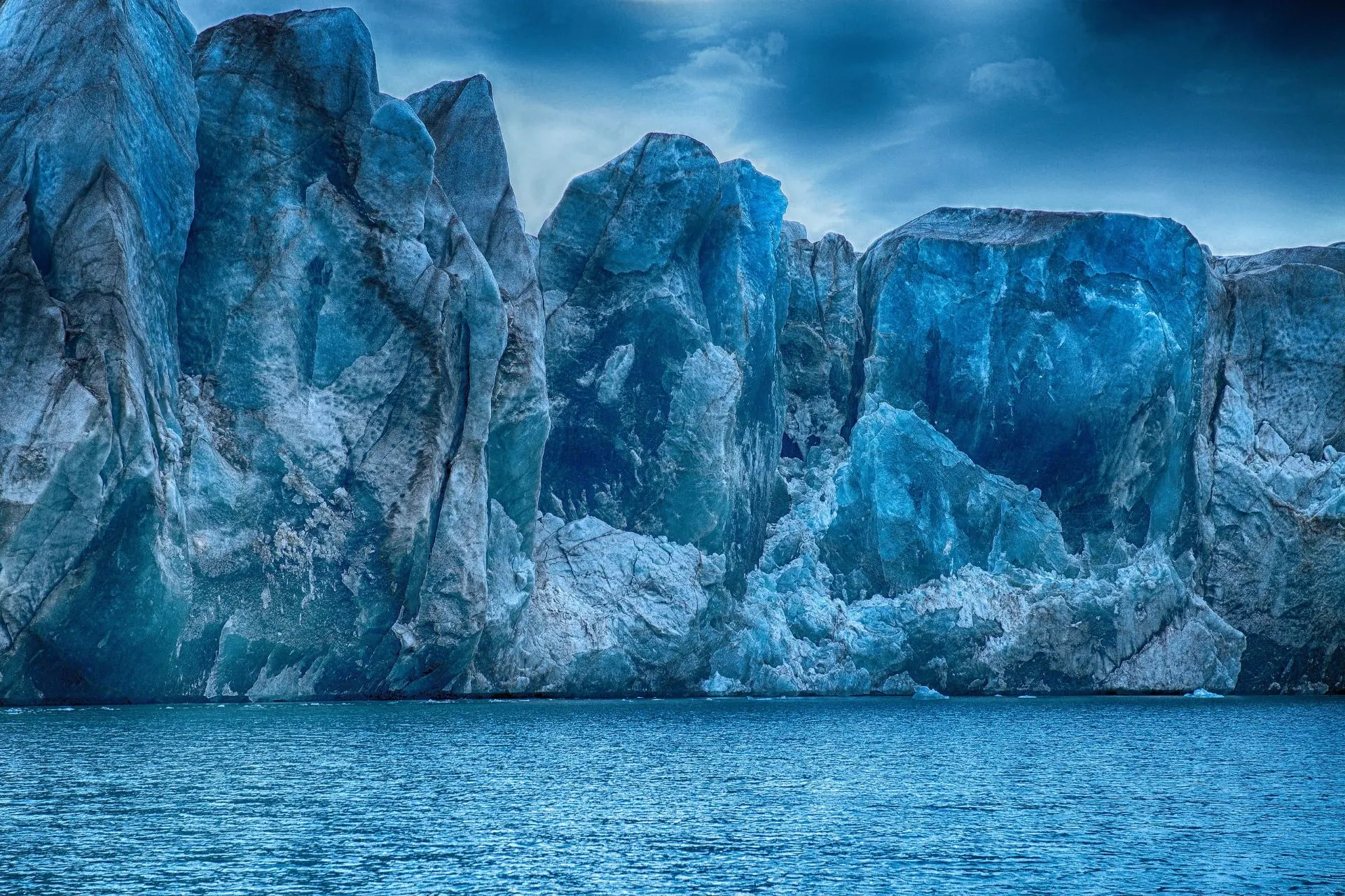 Torens van blauw ijs rijzen op uit het water in het poolgebied. Gletsjerwanden zoals deze zijn kenmerkend voor expedities naar Groenland en Spitsbergen.