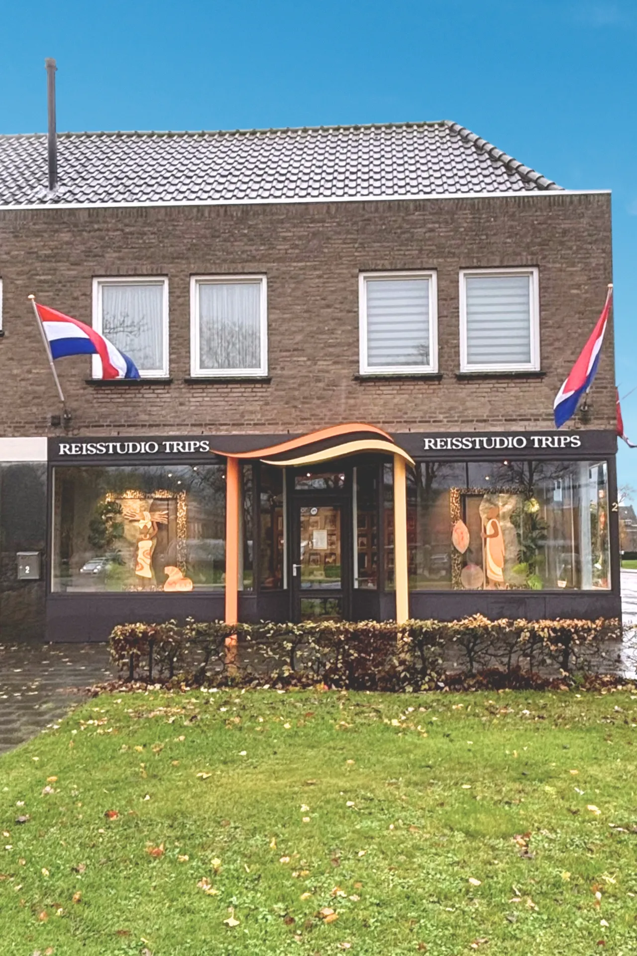 Vestiging Travelcenter de Wit filiaal in Asten, oude boerderij, Nederlandse vlag.