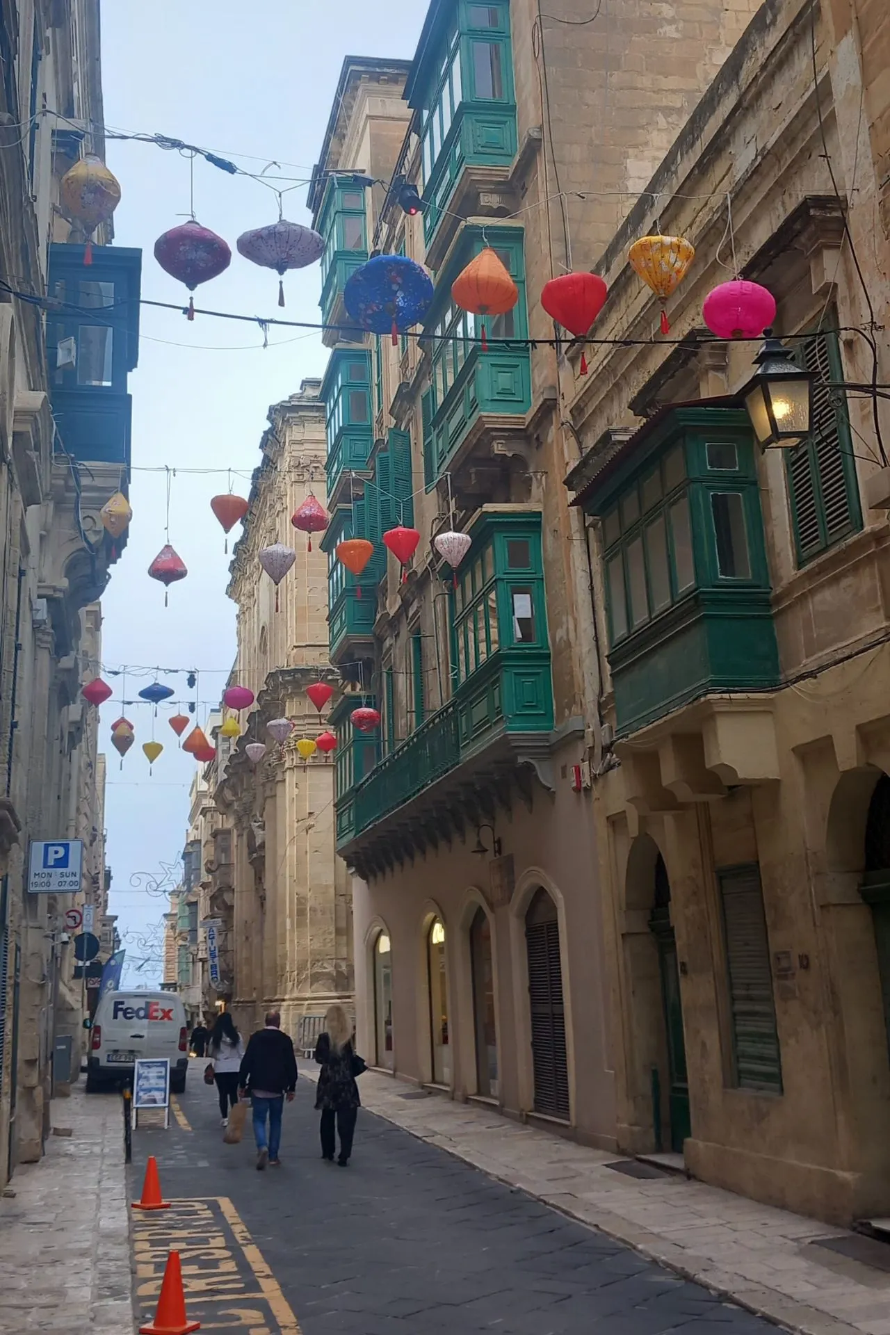 Smal, steil straatje met kleurrijke lampionnen in Valetta, Malta.