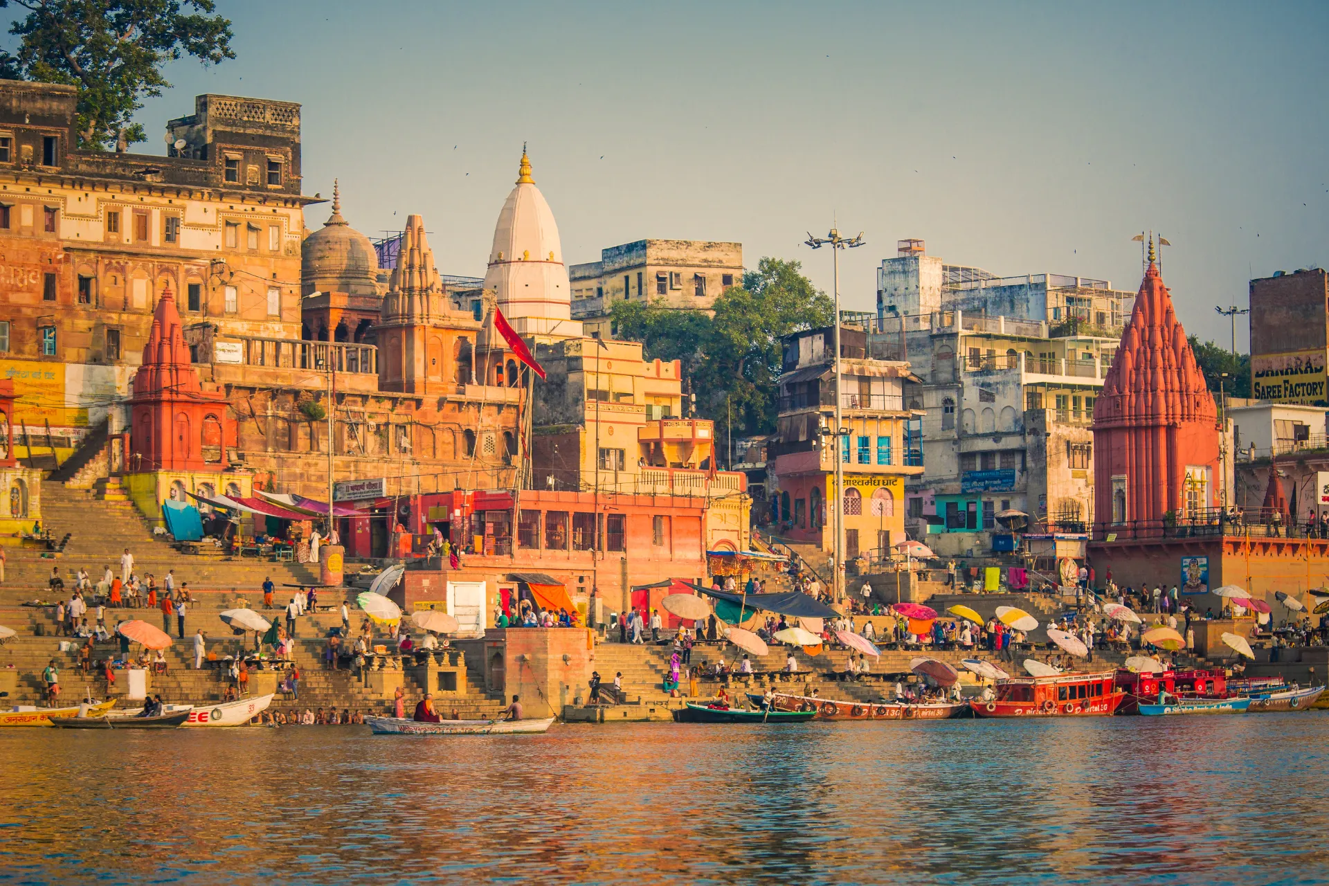 De kleurrijke ghats van Varanasi aan de rivier de Ganges, waar pelgrims en locals zich verzamelen voor rituelen en boottochten. Een spirituele en historische plek in India.