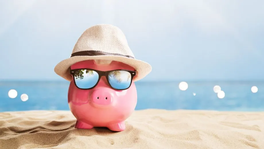 Spaarvarken aan zee als metafoor voor slim omgaan met vakantiegeld en reizen.