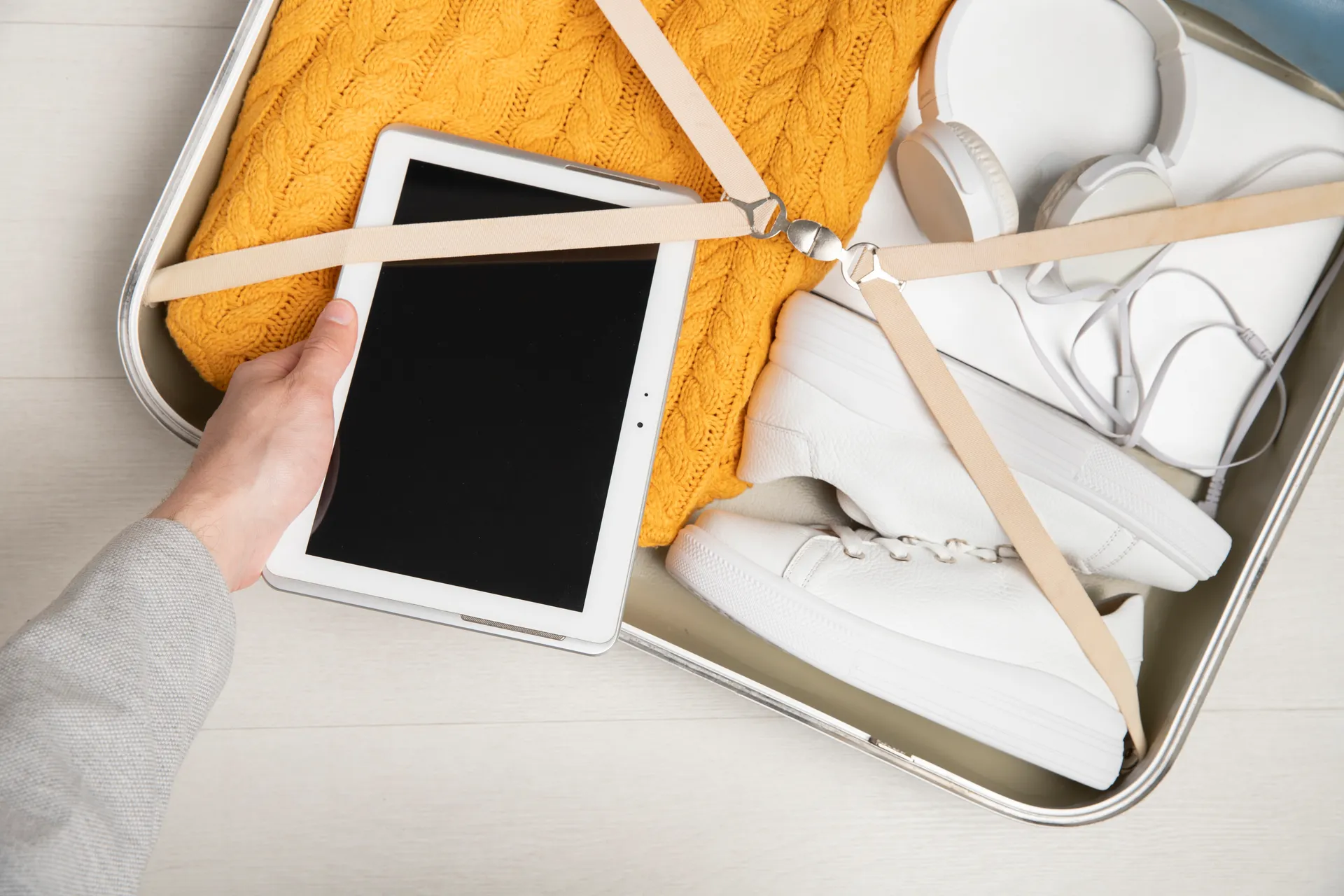 Elektronische apparaten in handbagage – laptop, smartphone en oplaadkabels veilig verpakt in een reistas.