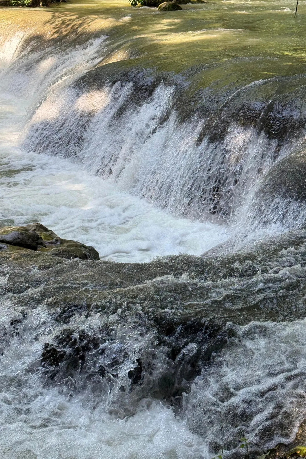 Stromend water dat bruisend naar beneden valt over de rotsen van YS Falls.