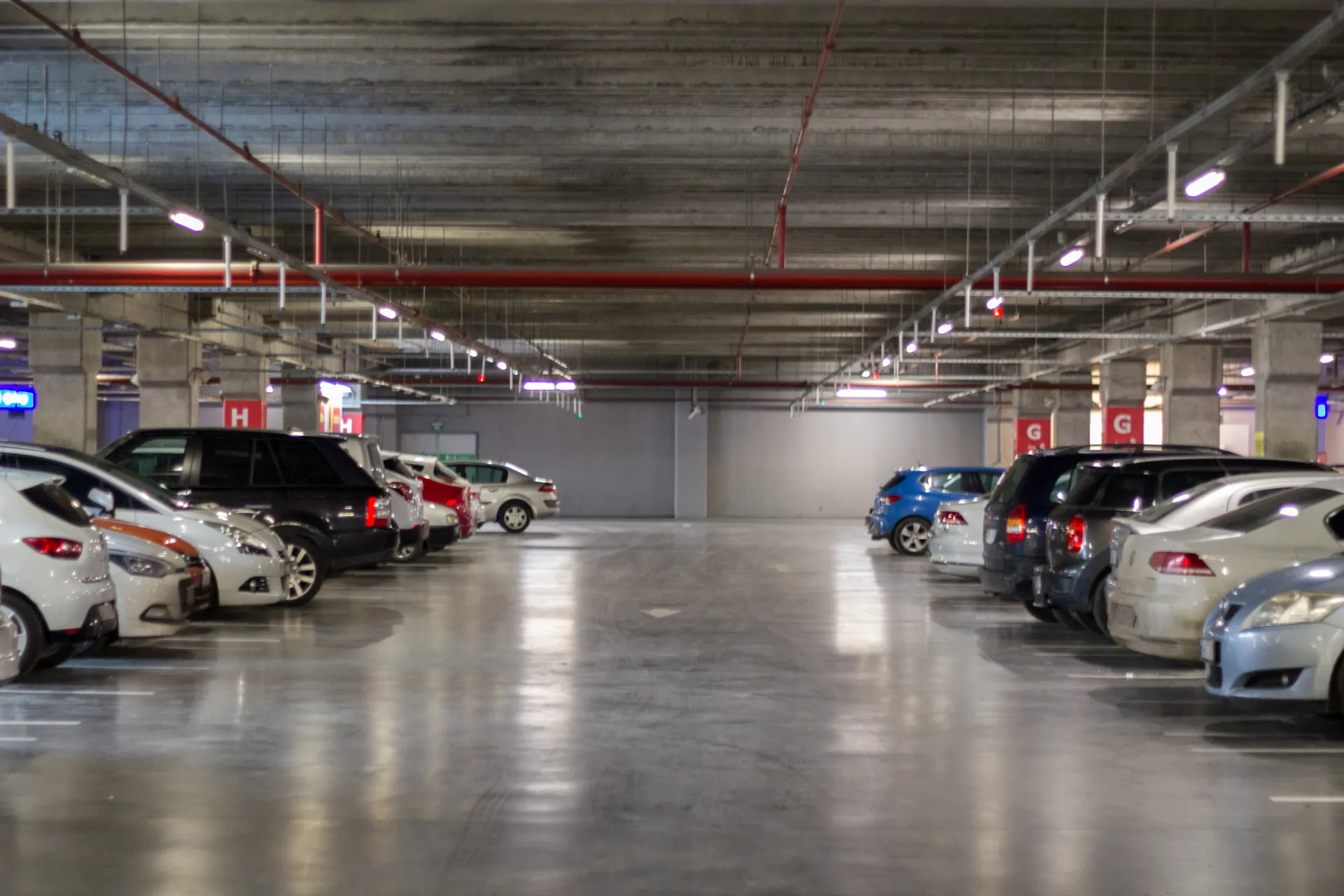 Een parkeergarage bij Schiphol met geparkeerde auto's, ideaal voor reizigers die hun auto veilig willen achterlaten voor hun vertrek vanaf Luchthaven Schiphol naar diverse bestemmingen Schiphol.
