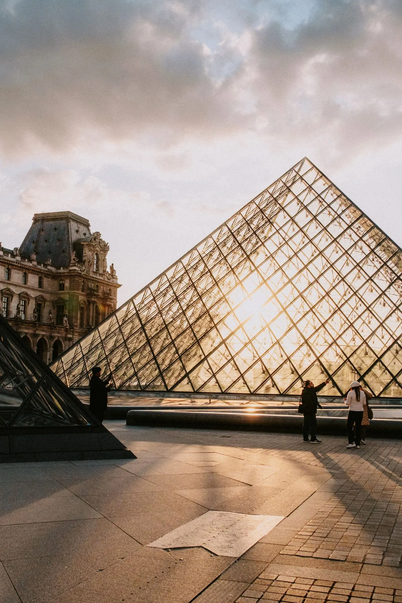 Het iconische Louvre in Parijs, met de beroemde glazen piramide in het voorgrond, symboliseert de rijke geschiedenis en kunst van de stad.