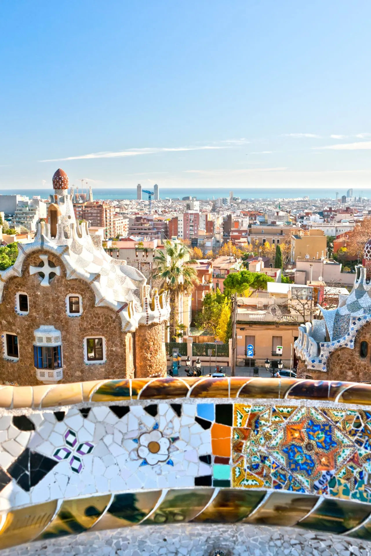 Foto van Park Güell in Barcelona, met kleurrijke mozaïeken, kronkelende bankjes en uitzicht over de stad.
