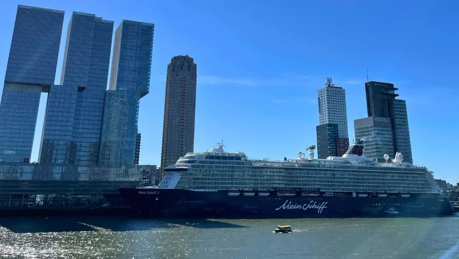 Cruiseschip Mein Schiff 3 aangemeerd aan de Wilhelminapier met de skyline van Rotterdam op de achtergrond
