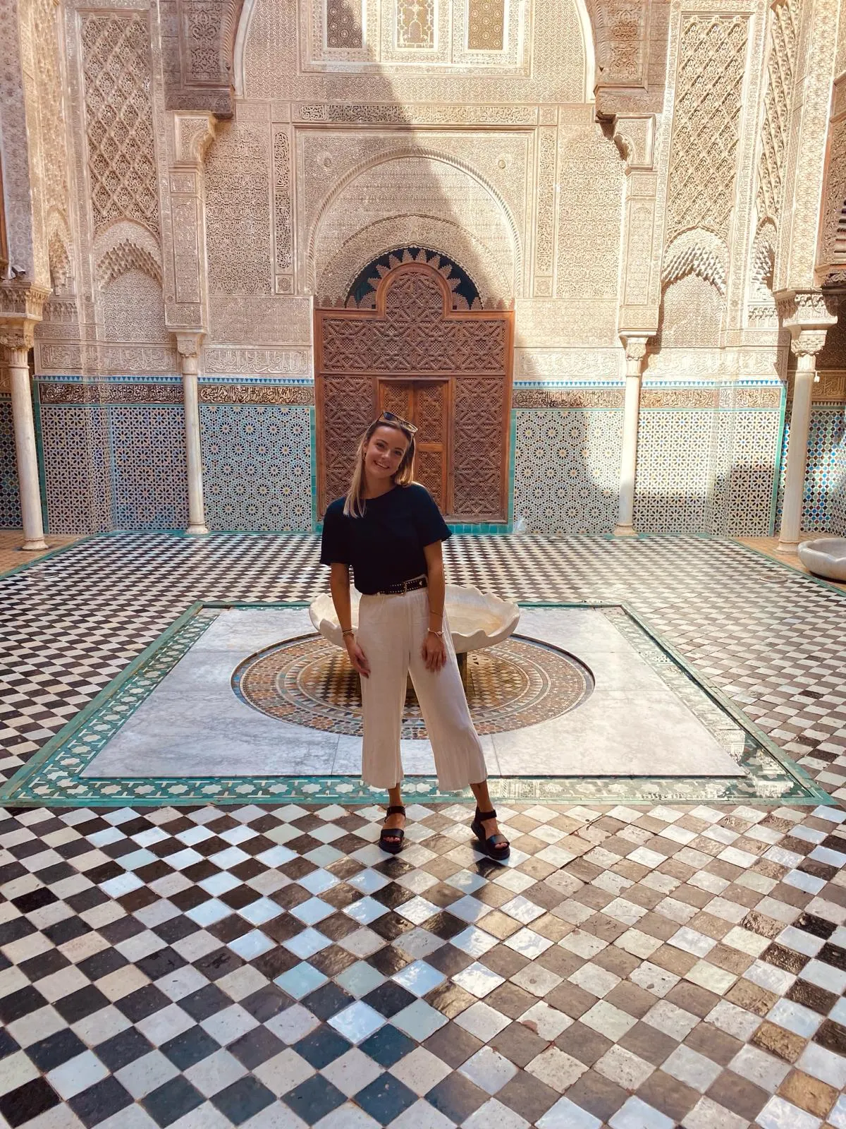 Floor in het Koninklijk Paleis van Fes, Marokko, omringd door prachtige Moorse architectuur en gedetailleerde gouden deuren.