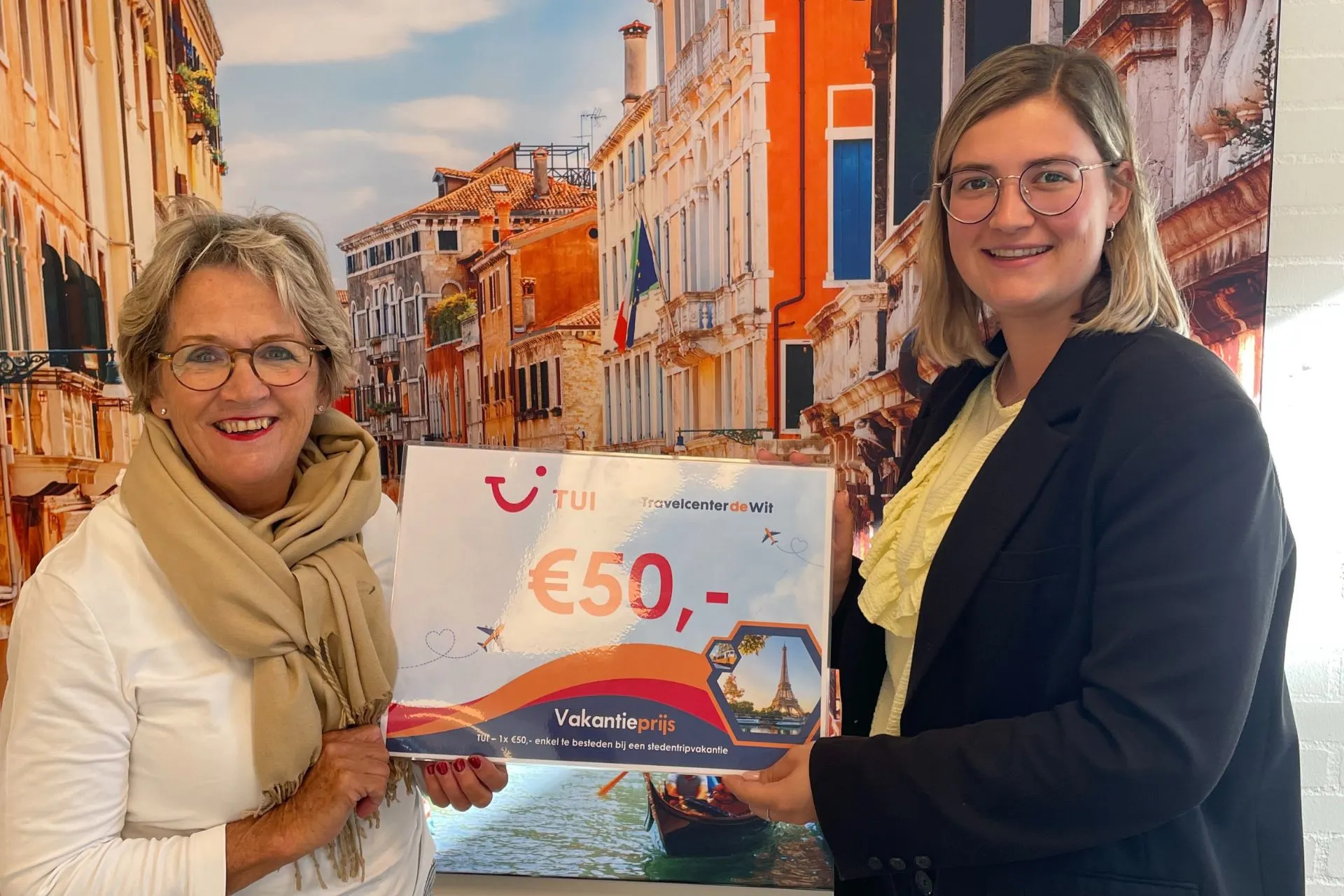 Twee vrouwen met een TUI-voucher van €50 bij Travelcenter de Wit Gemert tijdens de prijsuitreiking van de winactie.