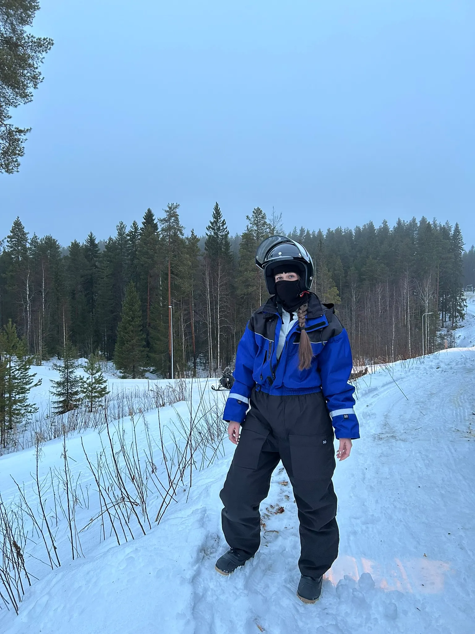 Dame warm ingepakt voor een sneeuwscooter safari in Arctic Lakeland Finland