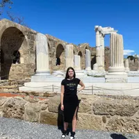 Dame met donker haar poseert bij de oude ruïnes van de Tempel van Apollo in Side, Antalya, Turkije