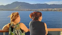 Reisadviseurs Karin en Joyce genietend van het uitzicht over de zee en bergen, vanaf het cruiseschip.