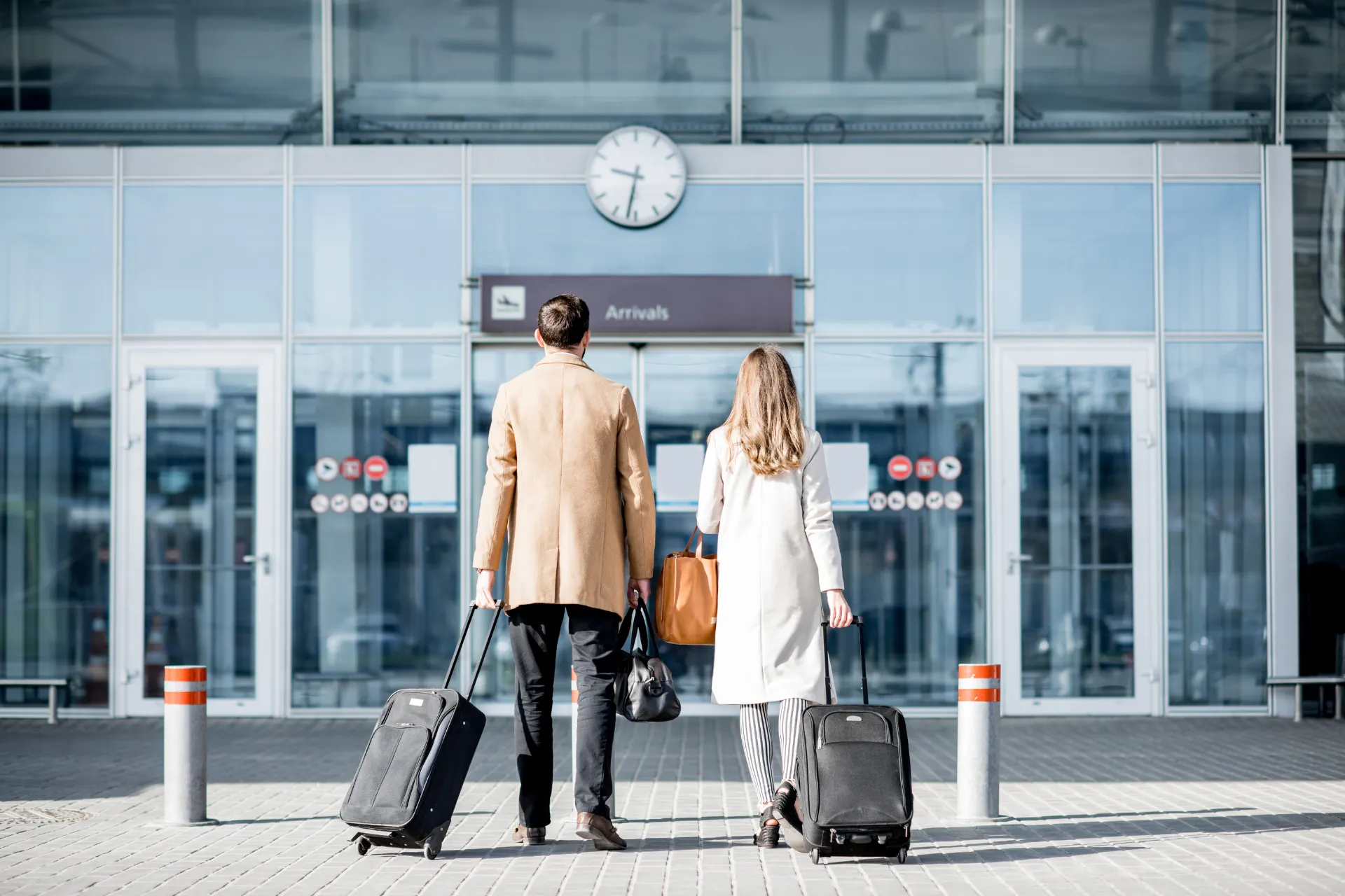 Een man en vrouw staan voor de luchthaven klaar voor vertrek vanaf luchthaven Brussel of luchthaven Zaventem. Kies voor vliegen vanaf Brussel of Zaventem en geniet van een ontspannen start van je reis met vluchten vanaf Brussel Airport.