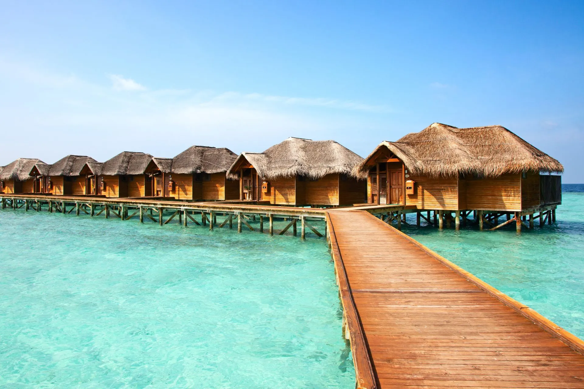 Het serene Baa Atol op de Malediven, met kronkelende steigers en luxe waterbungalows in helderblauw water.