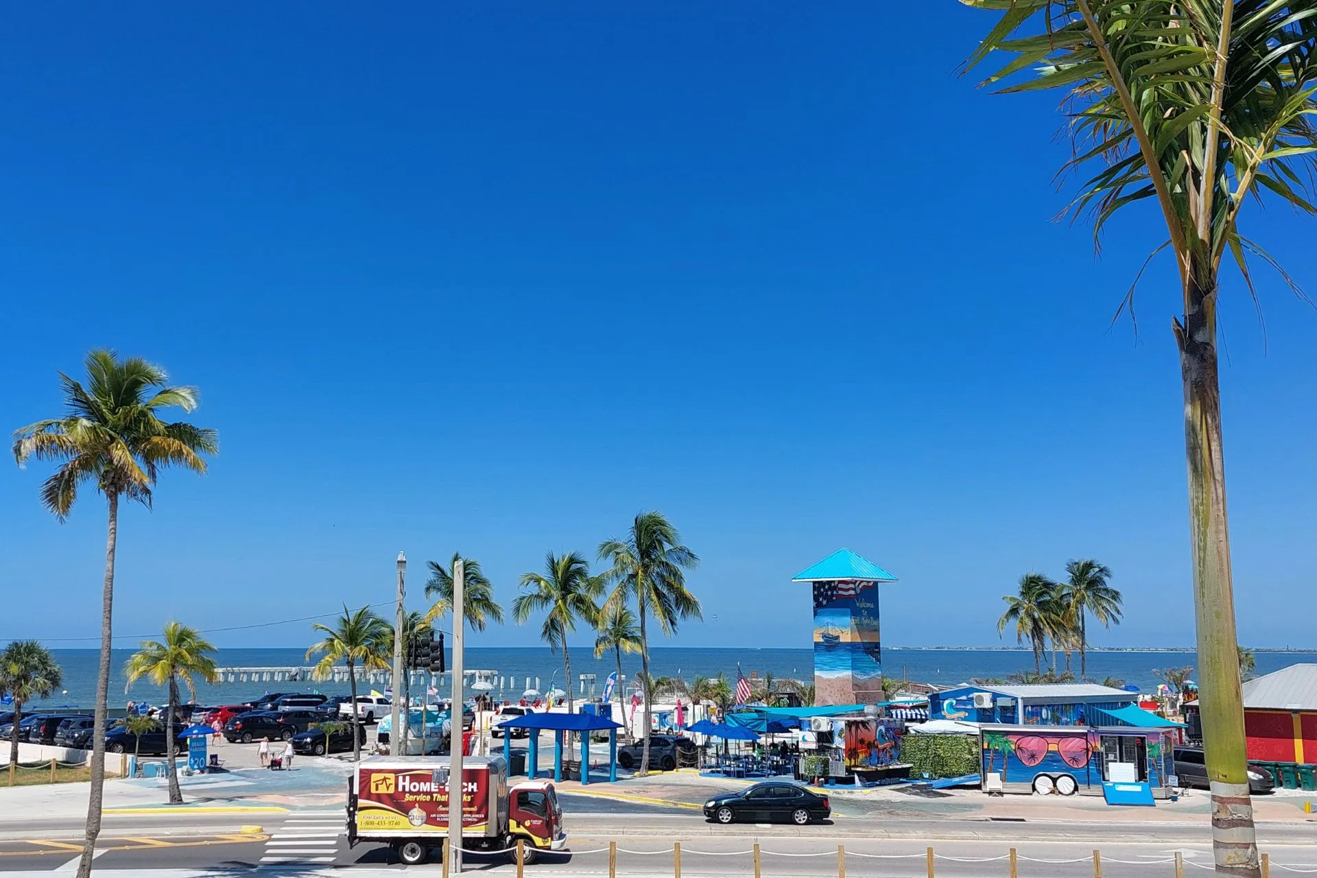 Uitzicht op een strandboulevard in Fort Myers, met palmbomen en kleurrijke kiosken aan de kust.