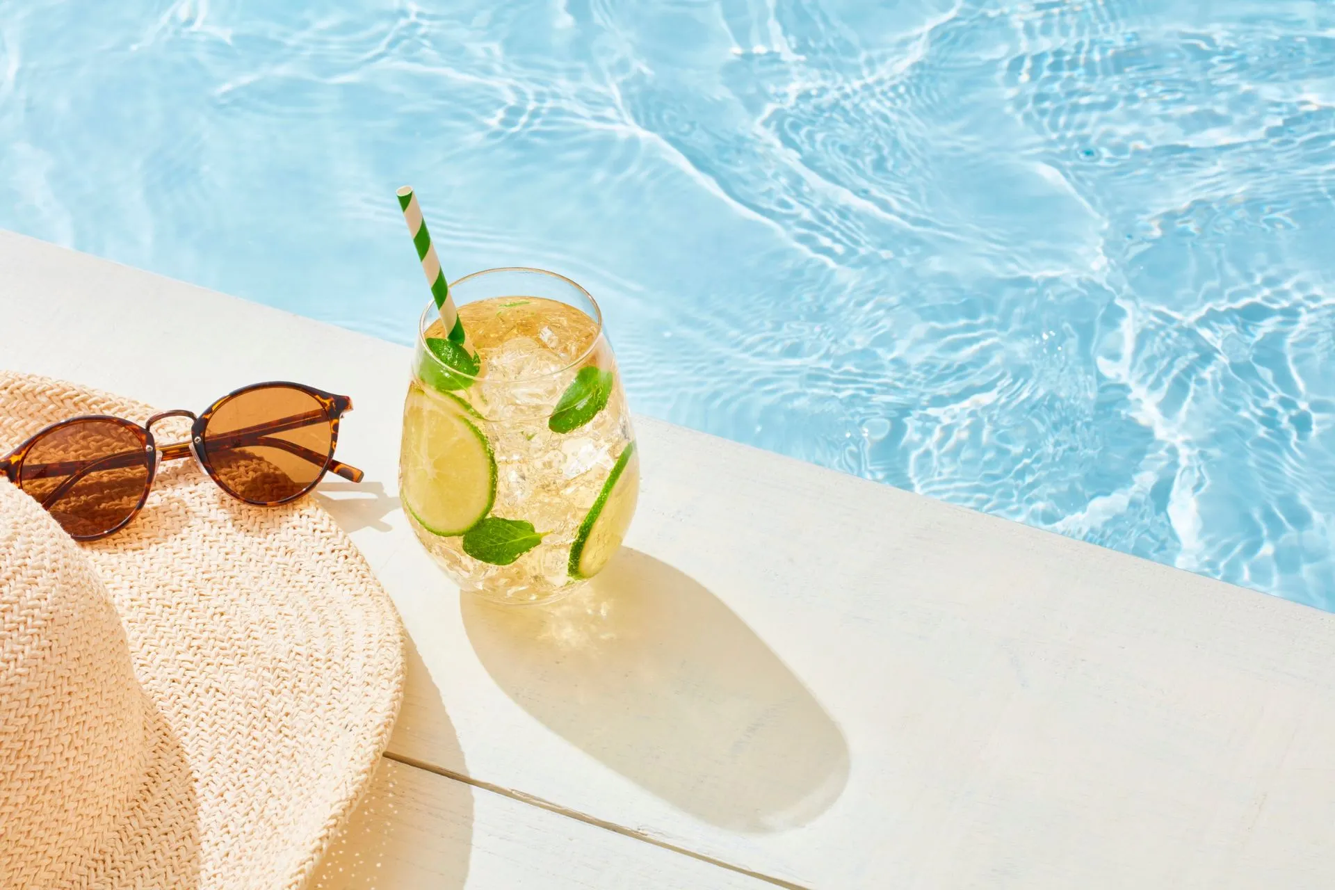 Zomerse sfeer aan het zwembad met een verfrissend drankje, zonnebril en hoed – het ultieme vakantiegevoel tijdens een all-inclusive zomervakantie in 2026, geboekt met vroegboekvoordeel bij Travelcenter de Wit.