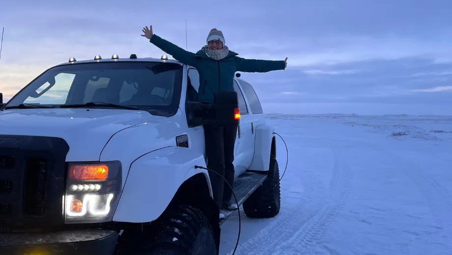 Reiziger staand op een superjeep tijdens een winterexcursie in Noord‑IJsland.
