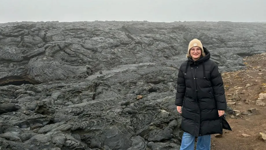 Reisadviseur Vera bij een veld van gestolde zwarte lava in een mistig landschap in Reykjanes, IJsland.
