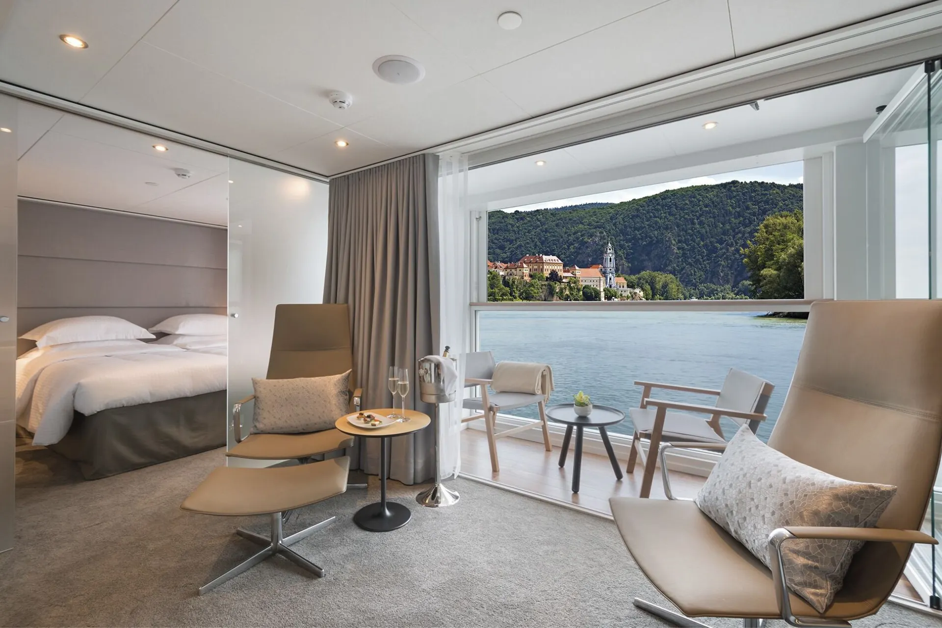 Luxe suite van Emerald Cruises in lichte beige en wit tinten met groot raam en uitzicht op het water