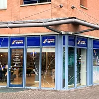 Hoek gebouw van filiaal Uden van Travelcenter de Wit. Rode stenen en blauwe kozijnen.