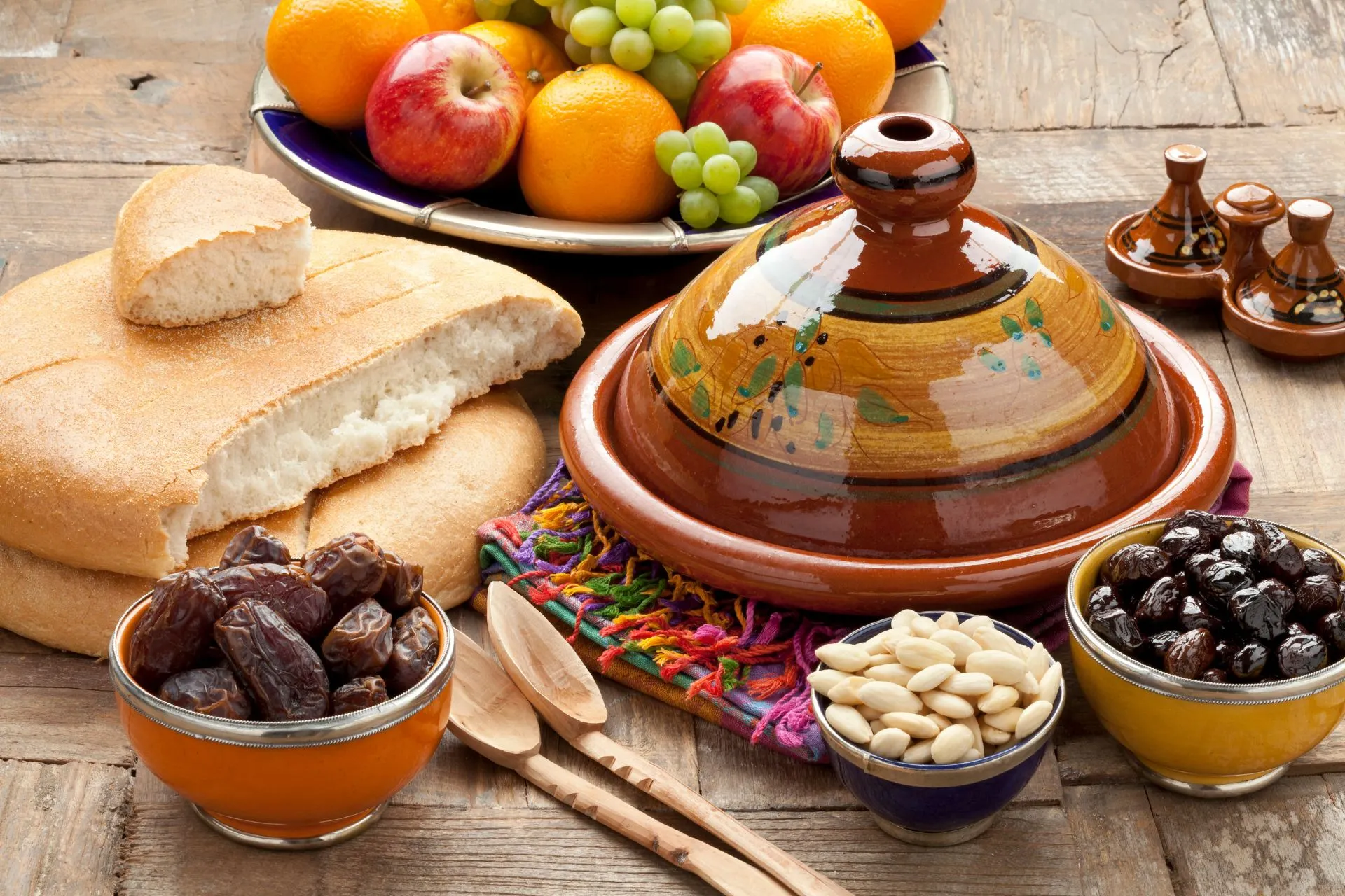 Een smakelijke selectie van traditioneel Marokkaans eten, waaronder tajine, couscous en vers gebakken brood, geserveerd met kleurrijke groenten en kruiden.