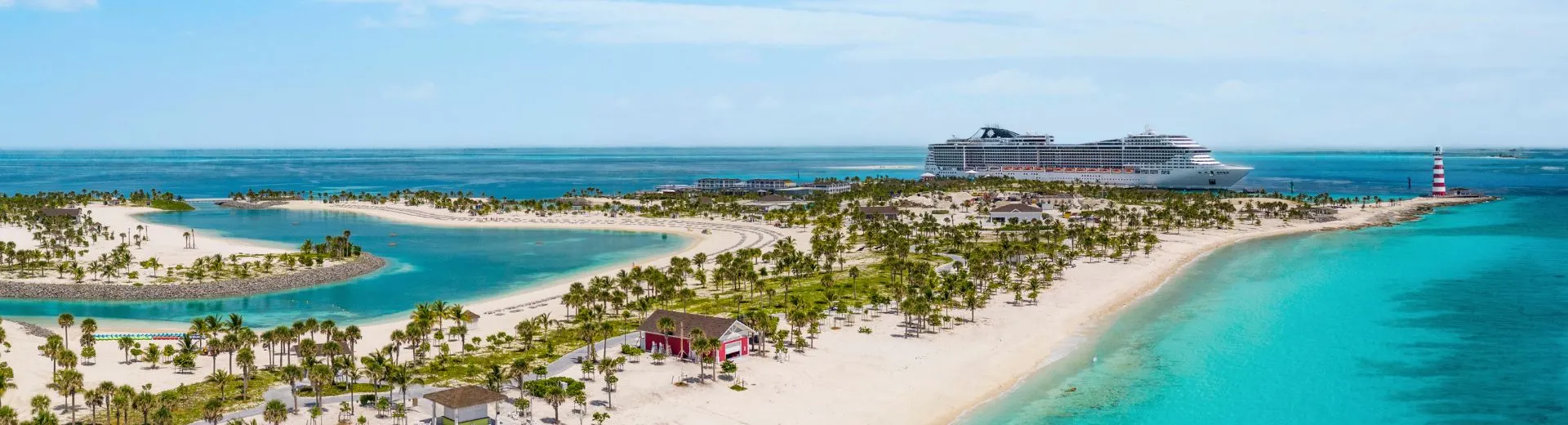Luchtfoto van Ocean Cay MSC Marine Reserve, het privé-eiland van MSC Cruises op de Bahama’s, met witte zandstranden, turquoise lagunes en palmbomen. Rechts op de achtergrond ligt het cruiseschip MSC Seashore aangemeerd aan de pier, met daarnaast een rood-witte vuurtoren. Het eiland toont verschillende strandhutten en wandelpaden te midden van het tropische landschap.
