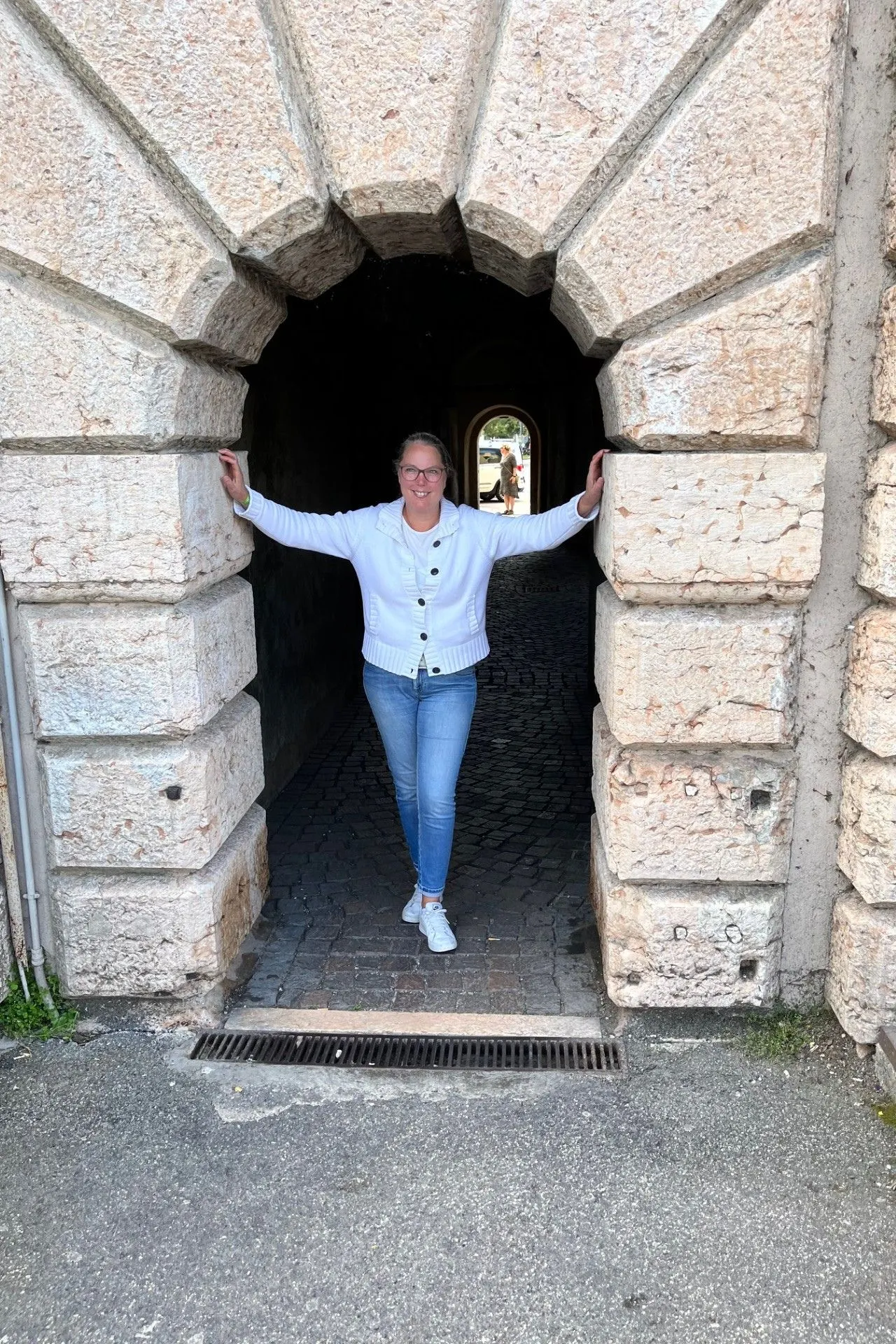 Historische stenen poort met robuuste blokken natuursteen en een doorgang naar een geplaveide straat. De architectuur straalt authenticiteit en middeleeuwse charme uit, perfect voor sightseeing en het ontdekken van historische monumenten. Ideale plek voor cultuurtoerisme en fotografie in een pittoreske mediterrane stad.

