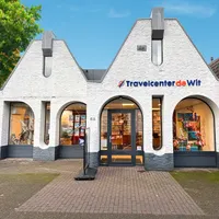 Vestiging Travelcenter de Wit in Gemert, mooie blauwe lucht en groene boom.