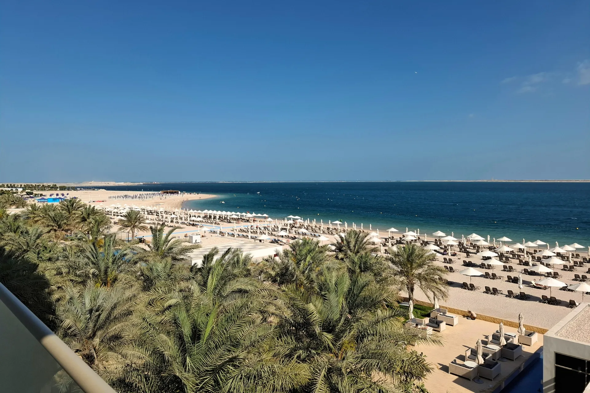 Uitzicht vanaf hotel RIU Dubai, met de zee, palmbomen en het zandstrand in de verte.