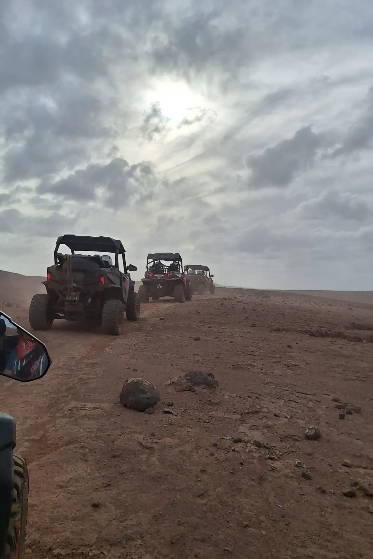 Offroad voertuigen rijden in colonne door het droge, ruige landschap van Kaapverdië onder een bewolkte lucht. Het stoffige terrein en het open uitzicht benadrukken het avontuurlijke karakter van het eiland. Deze scène past perfect bij een actieve vakantie Kaapverdië, waarbij excursies zoals quadtours en eilandverkenning centraal staan. Voor reizigers die kiezen voor avontuur naast ontspanning laat dit beeld de veelzijdigheid van het eiland Sal zien.