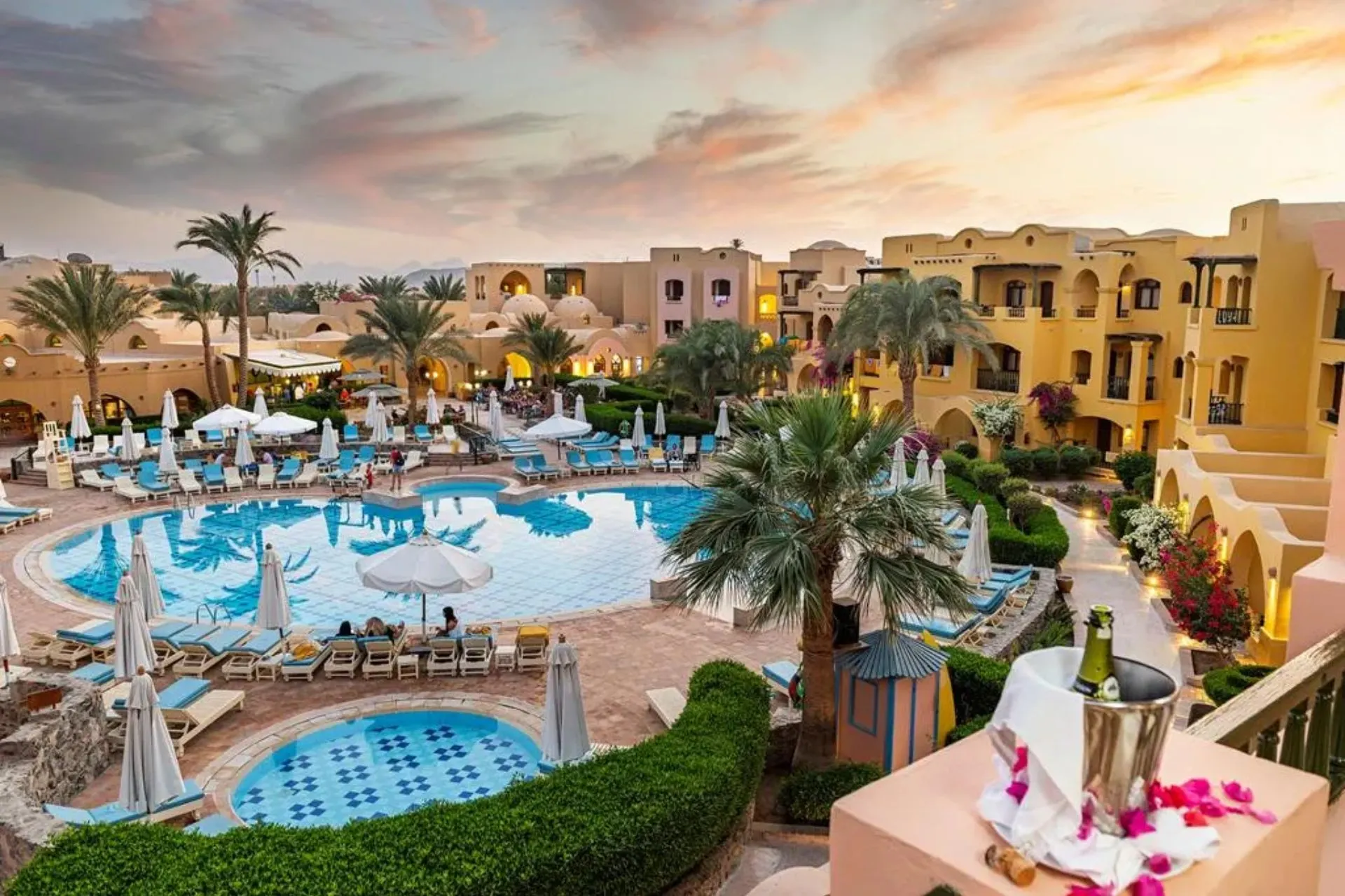 Entree van Three Corners Rihana Resort El Gouna met bloemen en palmbomen in Egypte