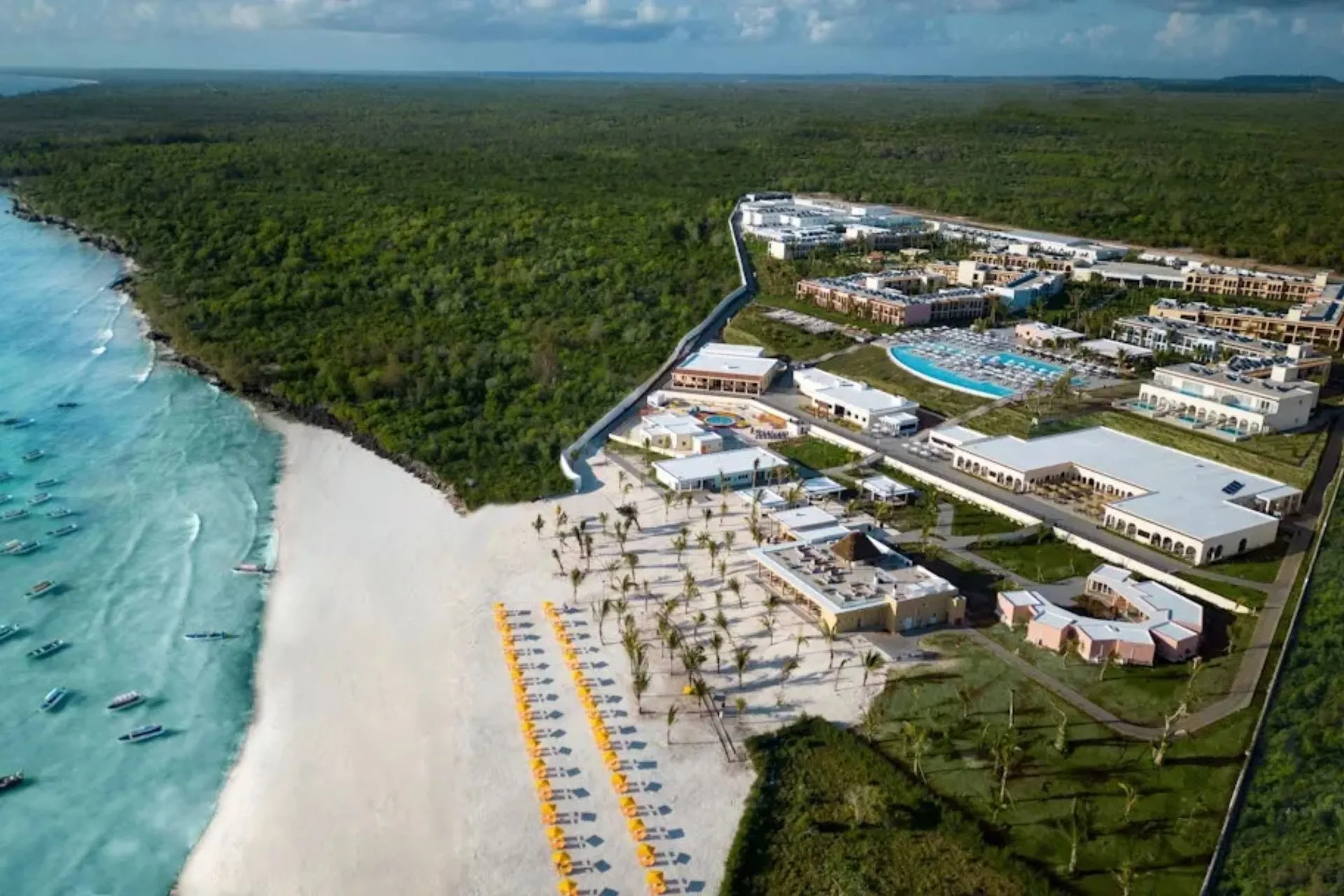 Luchtfoto van The Mora Zanzibar aan Muyuni Beach. Het grootschalige vijfsterrenresort ligt direct aan een breed wit zandstrand en beschikt over meerdere zwembaden, restaurants en tropische tuinen. Dankzij de ligging aan de noordkust geniet je hier van prachtig uitzicht en minder invloed van het getij.