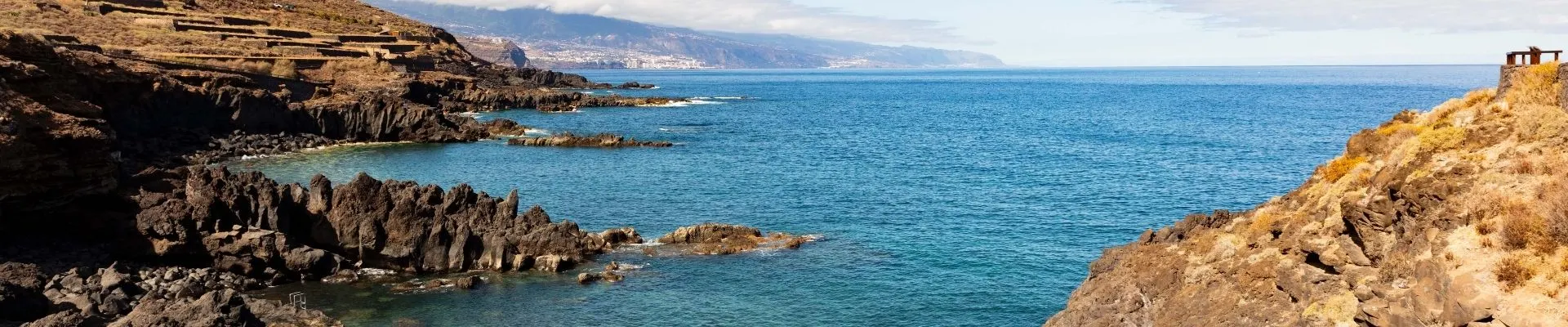 Ruige rotskust met helderblauwe zee en vulkanisch landschap aan de noordkant van het eiland