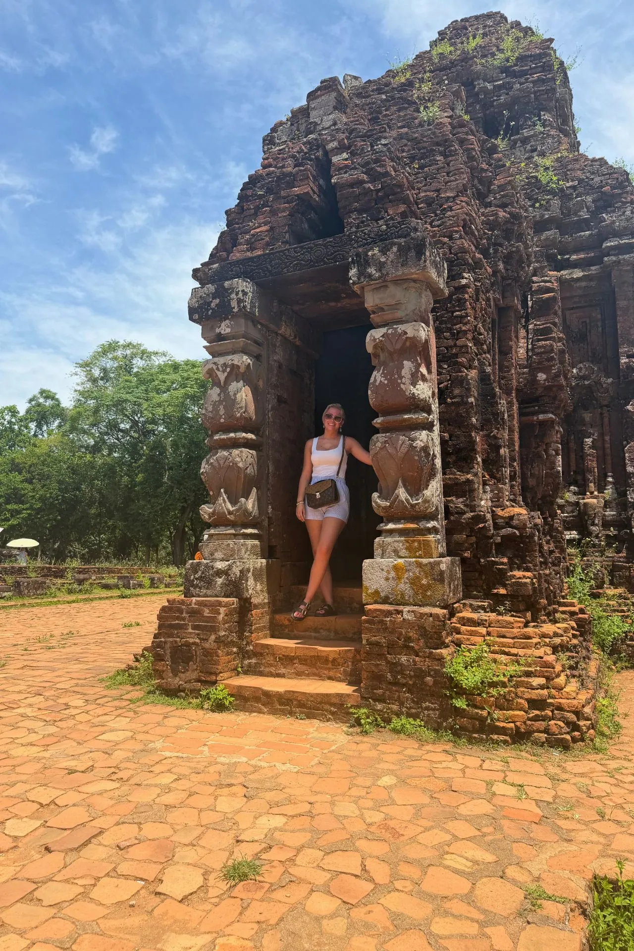 Oude bakstenen tempel in Mỹ Sơn Sanctuary, Vietnam, omringd door tropische natuur en eeuwenoude bomen. Dit UNESCO-Werelderfgoed was ooit het religieuze centrum van het Champa-rijk en behoort tot de belangrijkste historische bezienswaardigheden van centraal Vietnam.