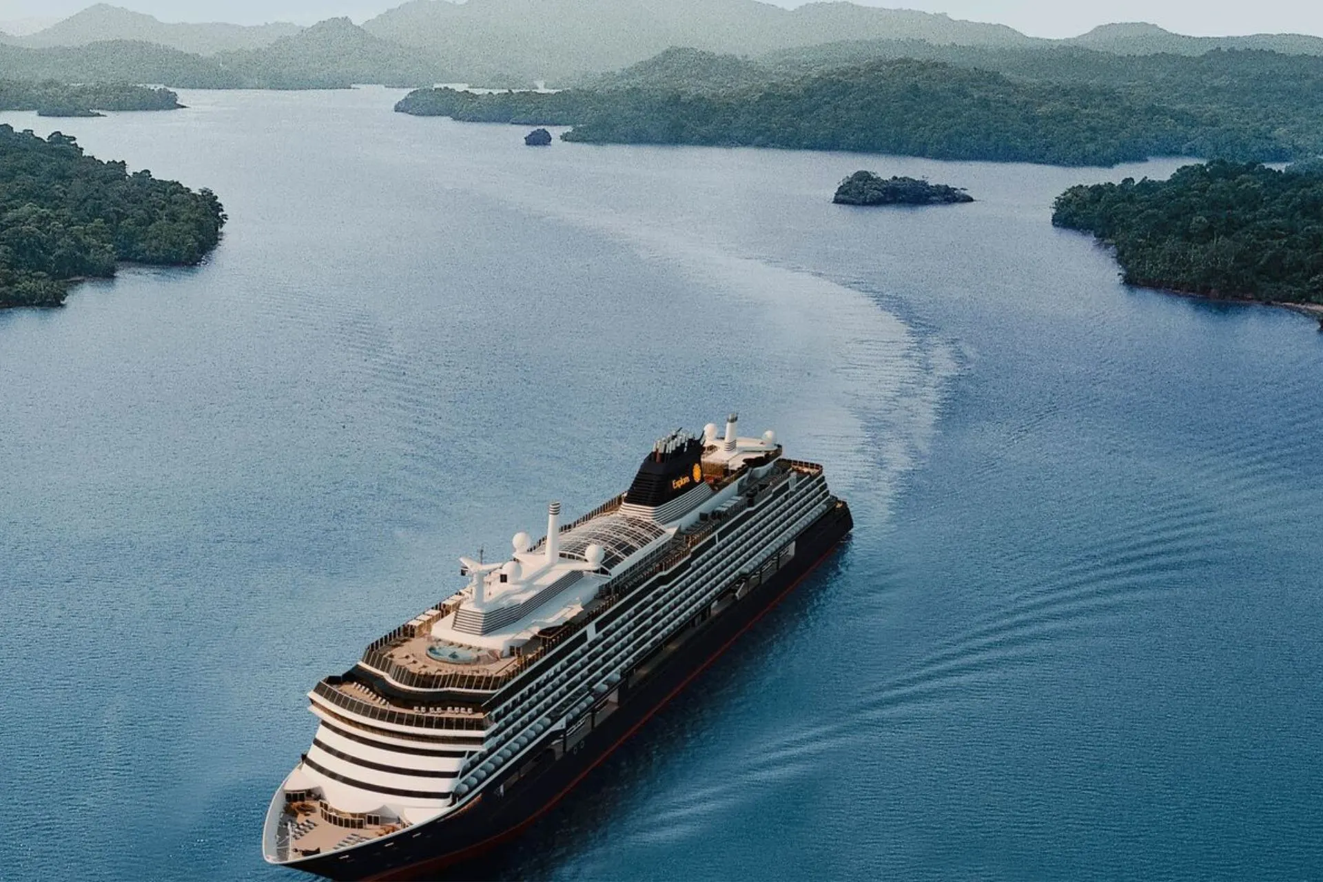 Luxe cruiseschip dat door een schilderachtige tropische omgeving vaart, omringd door groene eilanden en helderblauw water. Dit moderne schip biedt een unieke reiservaring met stijlvolle faciliteiten, ruime suites en eersteklas service. Perfect voor een droomcruise door exotische bestemmingen, waar natuur en comfort samenkomen. Ideaal voor reizigers die op zoek zijn naar een exclusieve vakantie vol ontspanning, avontuur en luxe op zee. Explora Journeys.